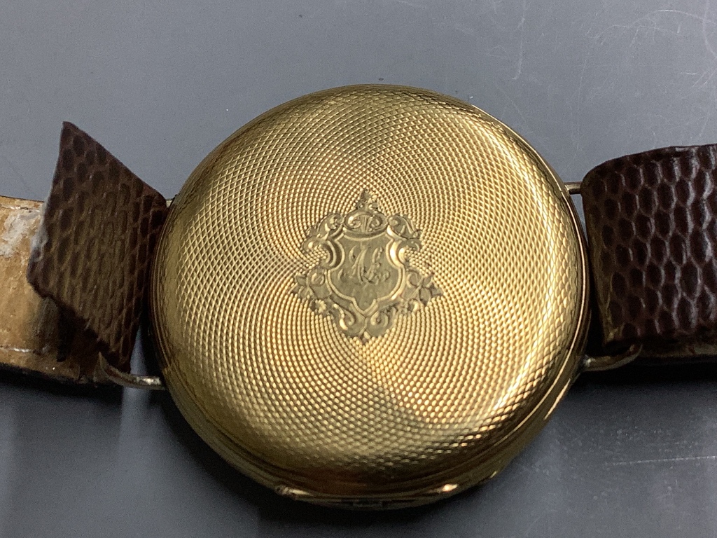 An early 20th century continental yellow metal open face pocket watch, converted to a wrist watch (a.f.)